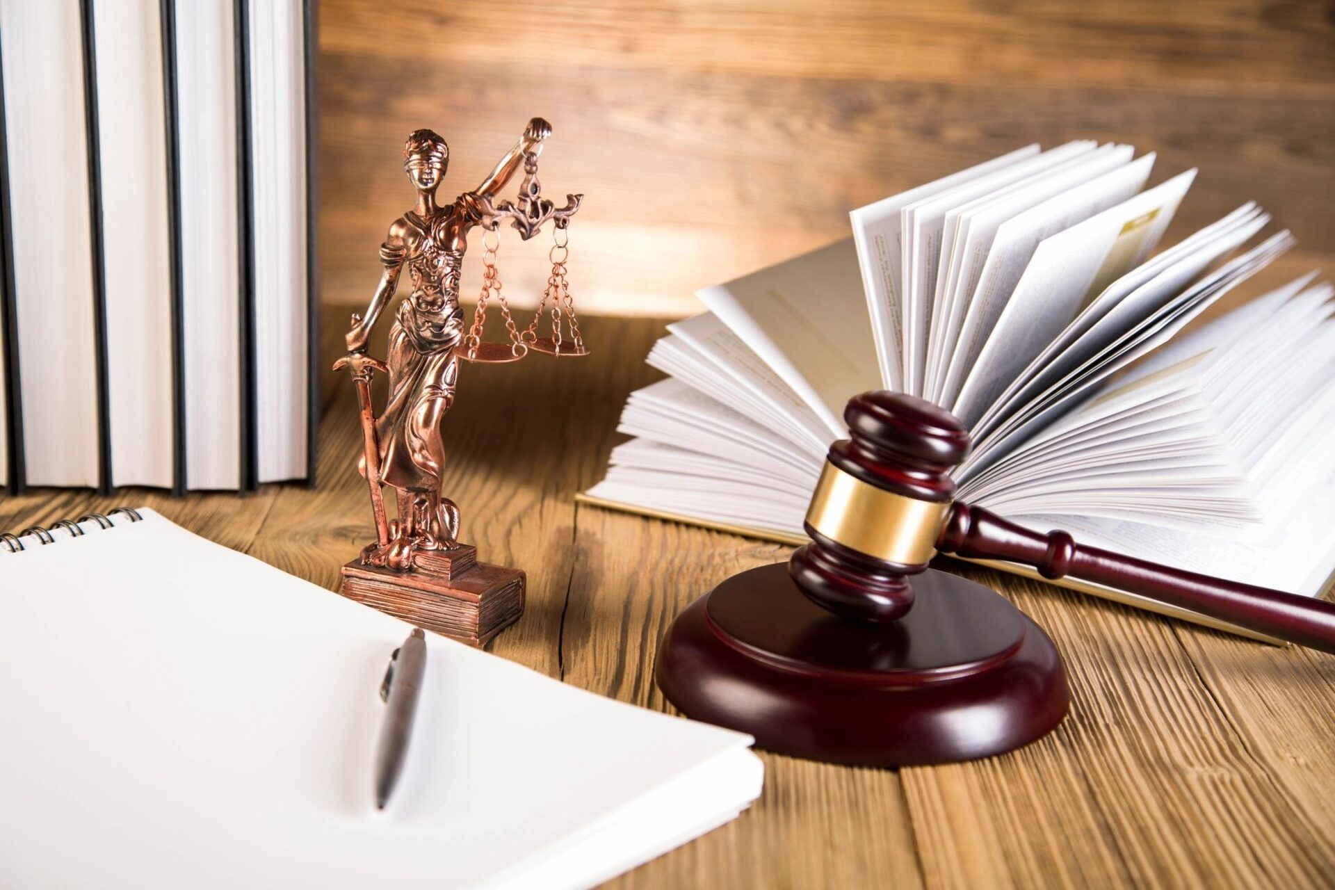 Lady of justice, wooden & gold gavel and books on wooden table